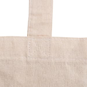 A close-up of a cream-coloured calico tote bag with a gusset, featuring stitching details and a handle.