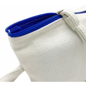 A cosmetic bag in cream with a blue zip, featuring a textured fabric and a handy side loop.