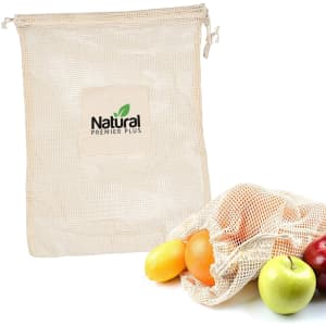 A beige mesh reusable produce bag next to various fresh fruits, including apples and oranges. The bag features a logo.
