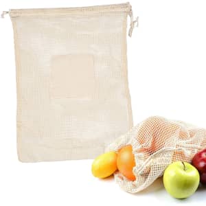 A beige mesh produce bag with a drawstring, lying next to apples, oranges, and lemons inside a similar bag.