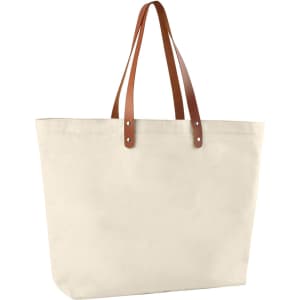 A cotton tote bag in cream with brown leather handles. It features a logo on one side.