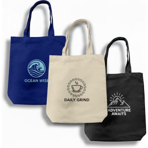 A navy blue tote bag with a wave logo, a natural canvas bag with a coffee design, and a black bag with a mountain logo.
