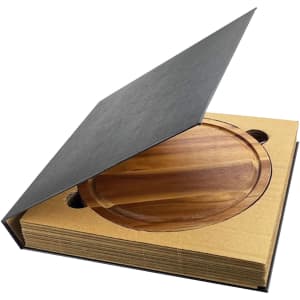 A wooden cheeseboard set within a stylish packaging, featuring a sleek black cover.