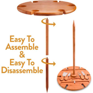 A wooden outdoor party table featuring a removable stake and compartments for utensils. The table is light brown in colour.