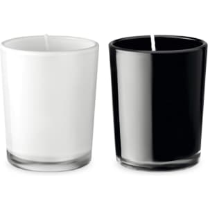 A glass candle set featuring one white and one black candle, each with a wick, in sleek glass containers.