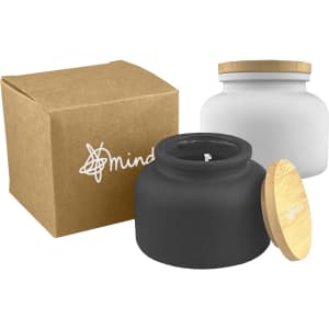 A black and white candle jar with a bamboo lid, presented alongside a recycled box. Features a logo.