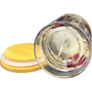 A floral candle with dried flowers encased in clear wax, featuring a bamboo lid.