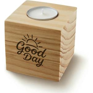A wooden cube candle with a metal holder for a tealight, featuring a sun design and the words "Good Day".