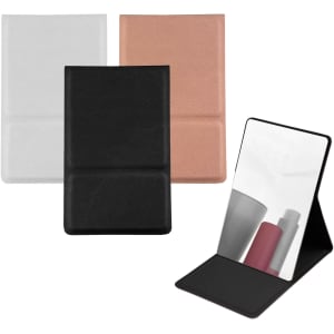 A compact mirror featuring a black, white, and rose gold exterior, with a standing design and reflective surface.