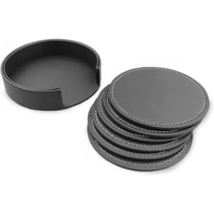 A set of six black leather coasters with white stitching, neatly arranged beside their round storage holder.