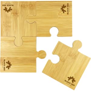 A bamboo coaster set featuring four puzzle-shaped pieces, coloured in natural bamboo tones, with a logo design.