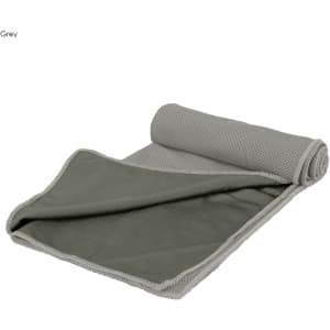 A grey cooling towel, featuring a textured surface and rolled at one end, displayed flat with a contrasting inner colour.
