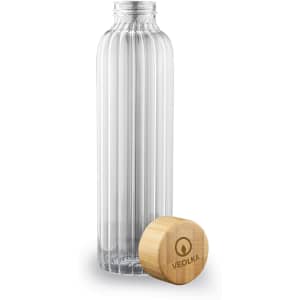 A drink bottle made of clear glass with a ribbed design, featuring a wooden cap and a logo.