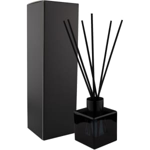 A black square reed diffuser with black reeds and a matching box. Stylish and minimalistic design for home décor.