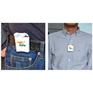 A pair of white earbuds in a compact carrying case, featuring a logo, attached to a belt and worn on a shirt.