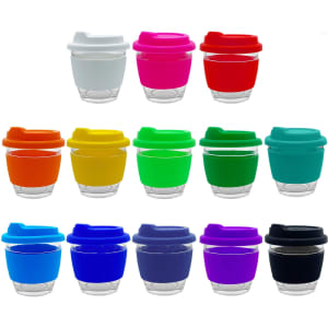 A collection of reusable coffee cups in various colours including white, pink, red, orange, yellow, green, teal, blue, and purple, with transparent bases and coloured lids.