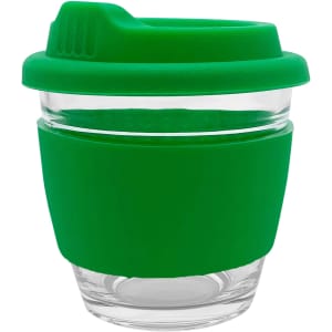 A reusable coffee cup with a transparent glass body and a green silicone sleeve and lid. It features a logo.