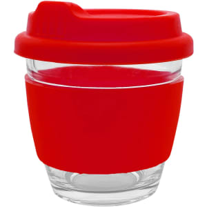 A reusable coffee cup with a clear glass body and a bright red silicone sleeve and lid. The cup features a logo.