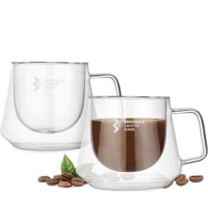 A set of transparent glass coffee cups with a sleek design, featuring a handle. Coffee beans are placed nearby.