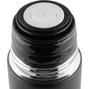 A drink bottle with a black exterior and a silver base, featuring an opening mechanism at the top and a logo.