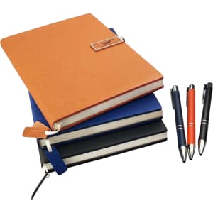 An orange notebook with a textured cover, stacked with blue and black notebooks, alongside four pens in various colours.