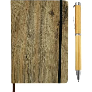 A wood look notebook with a black elastic band, next to a bamboo pen featuring a silver tip.