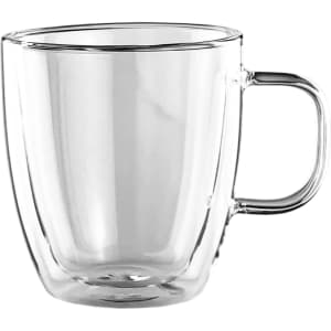 A double wall glass cup in clear glass with a curved shape and a handle, featuring a minimalist design.