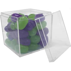 A clear cube container filled with green and purple jelly beans, partially open.