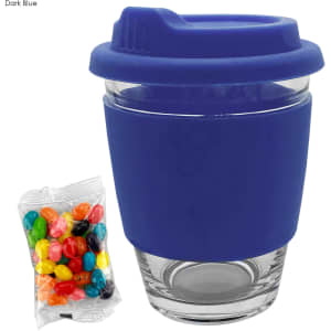 A dark blue coffee cup with a silicone lid and a clear glass body, accompanied by a bag of colourful jelly beans.