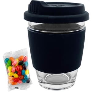 A clear glass coffee cup with a black silicone sleeve and lid, alongside a pack of colourful jelly beans.