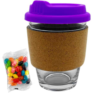 A glass coffee cup with a cork band and purple lid, accompanied by a packet of colourful jelly beans.