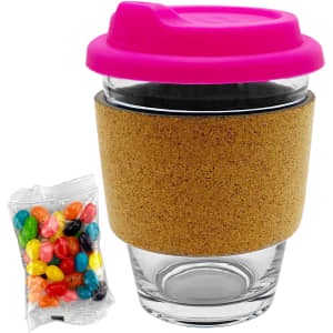 A glass coffee cup with a pink lid and cork band, accompanied by a packet of colourful jelly beans.