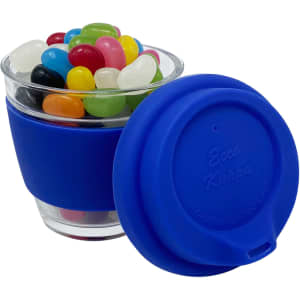 A glass coffee cup with a blue silicone sleeve, filled with colourful jelly beans. The lid is also blue.