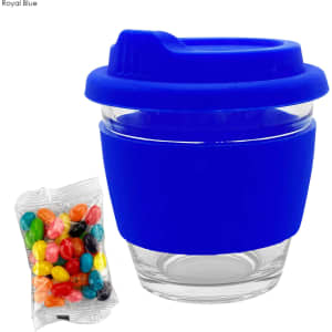 A reusable glass coffee cup in royal blue featuring a silicone sleeve, accompanied by a pack of colourful jelly beans.