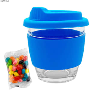 A reusable glass coffee cup with a light blue silicone lid and sleeve, accompanied by a pack of colourful jelly beans.