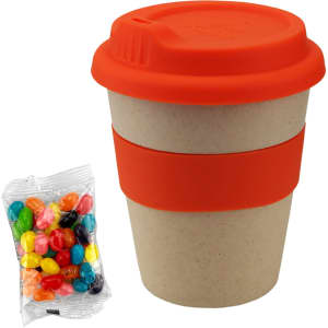 A bamboo cup in natural tones with an orange lid and sleeve, alongside a packet of colourful jelly beans.