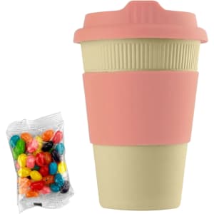 A reusable 12oz bamboo cup in beige with a pink silicone sleeve, accompanied by a pack of colourful jelly beans.