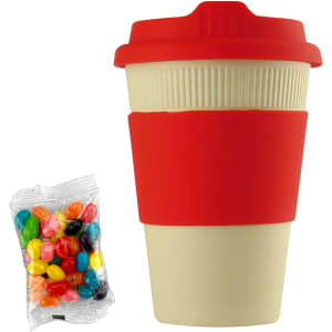A reusable coffee cup in cream and red with a silicone sleeve, accompanied by a pack of jelly beans.