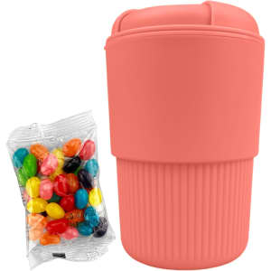 A reusable coffee cup in coral with a ribbed design, accompanied by a bag of colourful jelly beans.