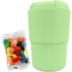A mint green reusable coffee cup with a textured grip, accompanied by a pack of colourful jelly beans.