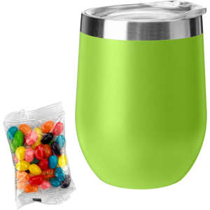 A green coffee mug with a stainless steel rim beside a bag of colourful jelly beans.