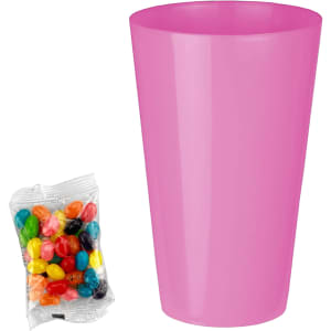 A pink party cup next to a clear bag of colourful jelly beans in assorted flavours.