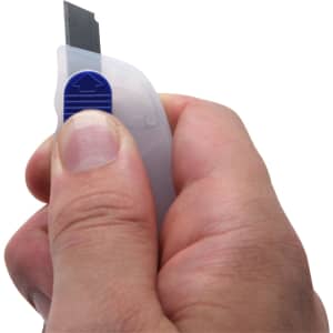 A Mini Cutter Key Ring held in a hand, featuring a white body and a blue button for blade release.