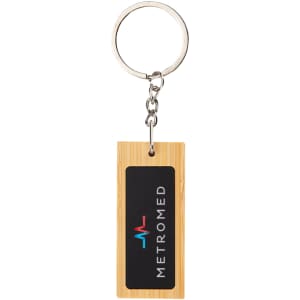 A rectangular bamboo keyring featuring a black insert with a logo. The keyring has a silver metal ring attachment.