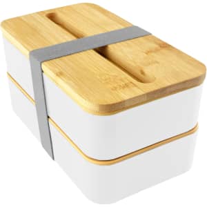 A two-tiered bamboo lunch box pack in white with a bamboo lid and a grey elastic strap for secure closure.
