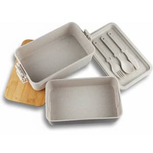 A stackable bamboo lunch box in beige, featuring two containers and a wooden lid, with utensils included.