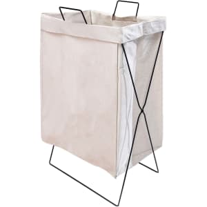 A cotton laundry basket with a beige fabric body and a black metal frame, featuring two handles on top.