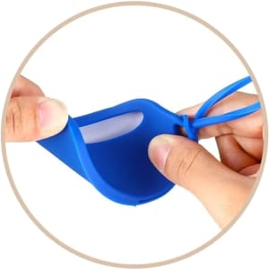A blue silicone luggage tag being held, showcasing its flexible design and transparent window for identification.