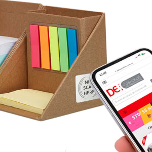 A memo holder in brown cardboard with bright sticky notes in pink, green, yellow, and blue; next to a smartphone.