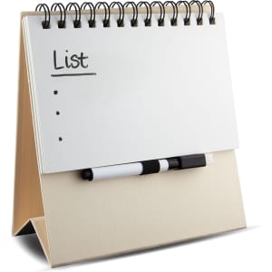 A whiteboard notepad with a spiral binding and a black marker, resting on a beige stand.